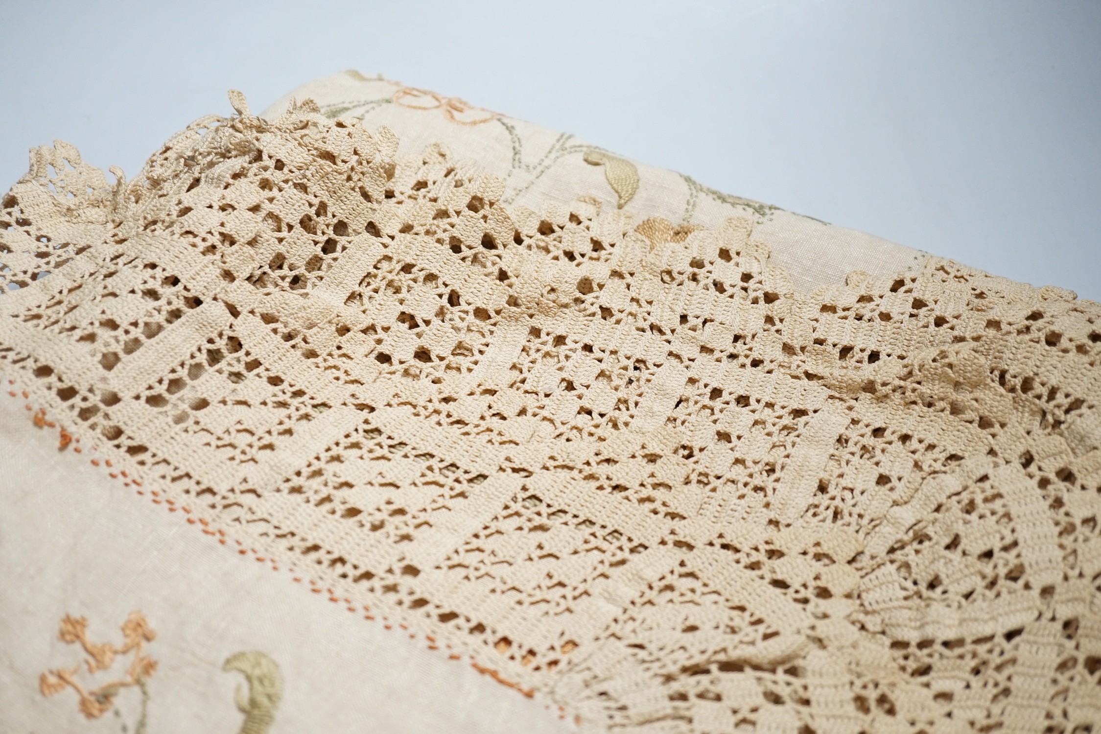 A 19th century Arts and Crafts bedcover; embroidered on linen in panels with crochet edges and borders